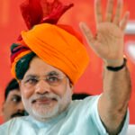 Gujarat's CM Modi wears traditional Indian turban as he waves to his supporters on second day of his fast in Ahmedabad